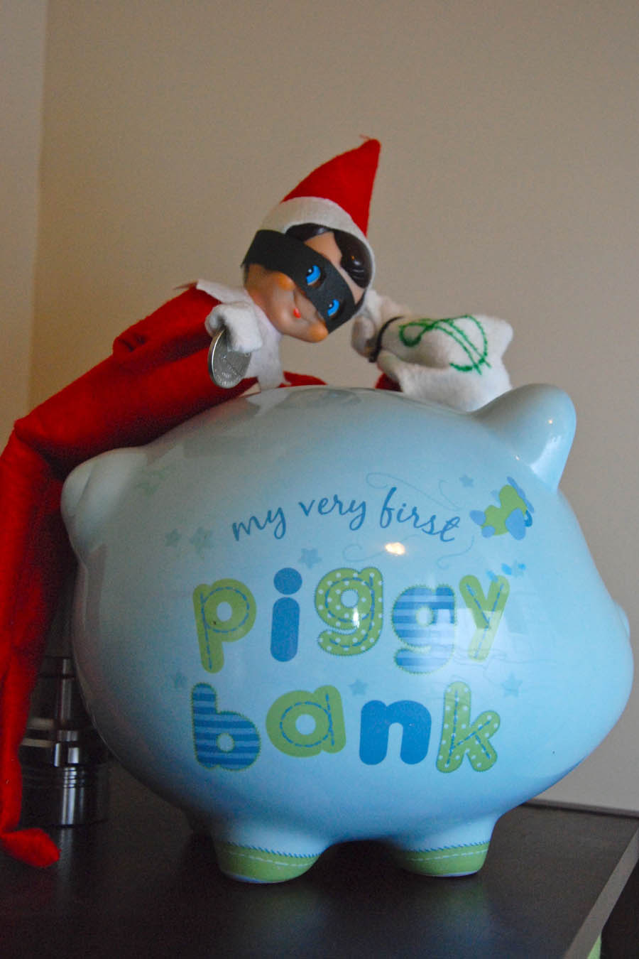 30 fun and unique Elf on the Shelf Ideas - Elf On the Shelf Bandit breaking into piggy bank
